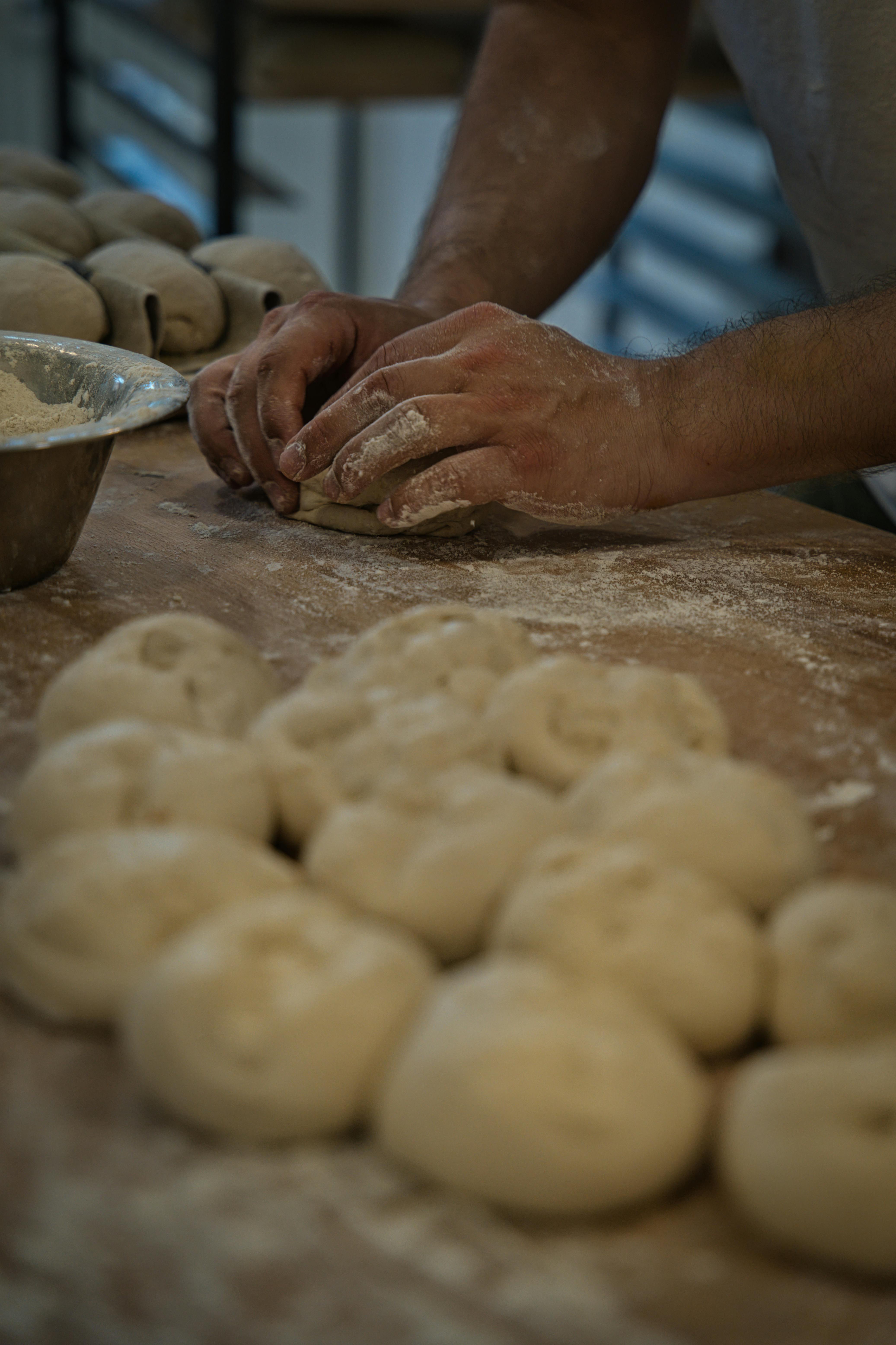 Bakker die met de hand plantaardige brooddeegjes vormt